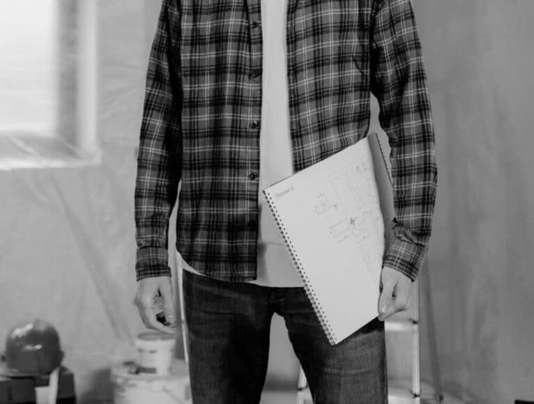 Person holding architectural plans in renovation space
